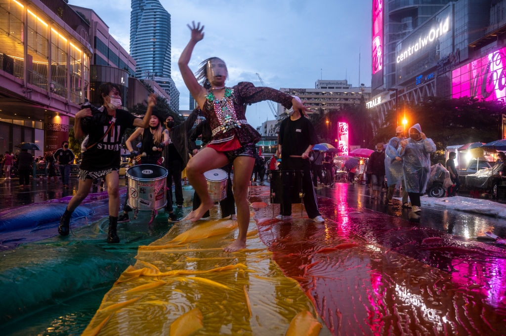 Protesters dances on pride flag in heavy rain while attending the anti-government gathering in downtown on October 31, 2021 in Bangkok, Thailand.  (Photo by Sirachai Arunrugstichai/Getty Images)