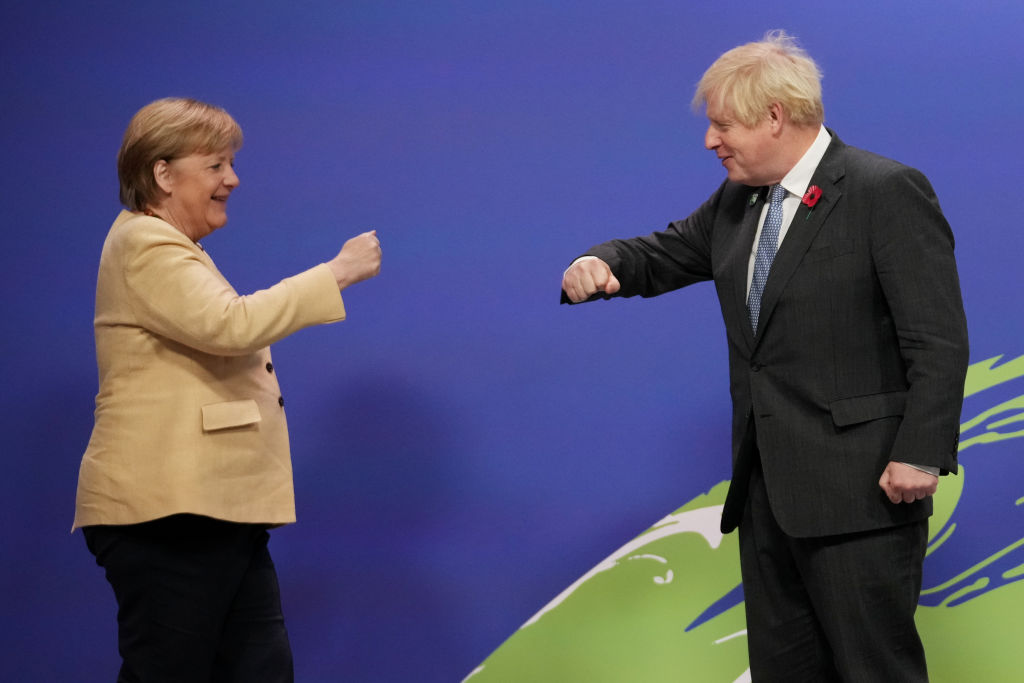 GLASGOW, SCOTLAND - NOVEMBER 01: British Prime Minister Boris Johnson (R) greets German Chancellor Angela Merkel as they arrive for day two of COP26 at SECC on November 1, 2021 in Glasgow, Scotland. 2021 sees the 26th United Nations Climate Change Conference. The conference will run from 31 October for two weeks, finishing on 12 November. It was meant to take place in 2020 but was delayed due to the Covid-19 pandemic. (Photo by Christopher Furlong/Getty Images)