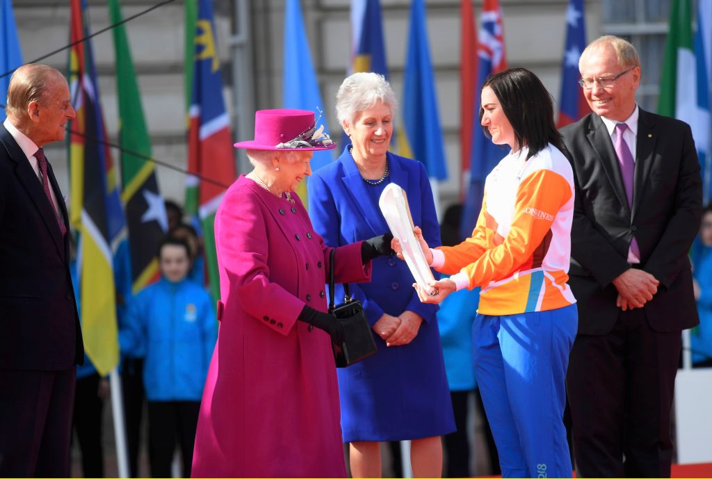 LONDON, UNITED KINGDOM - MARCH 13: Retired cyclist Anna Mears from Australia receives the baton from Queen Elizabeth during the launch of The Queen's Baton Relay for the XXI Commonwealth Games being held on the Gold Coast in 2018 at Buckingham Palace on March 13, 2017 in London, United Kingdom. (Photo by Toby Melville - WPA Pool/Getty Images)