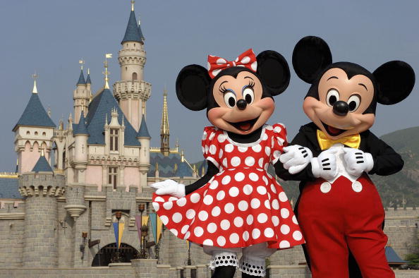 Famous Disney characters Mickey and Minnie Mouse are seen in front of the Sleeping Beauty Castle at Disneyland Park.