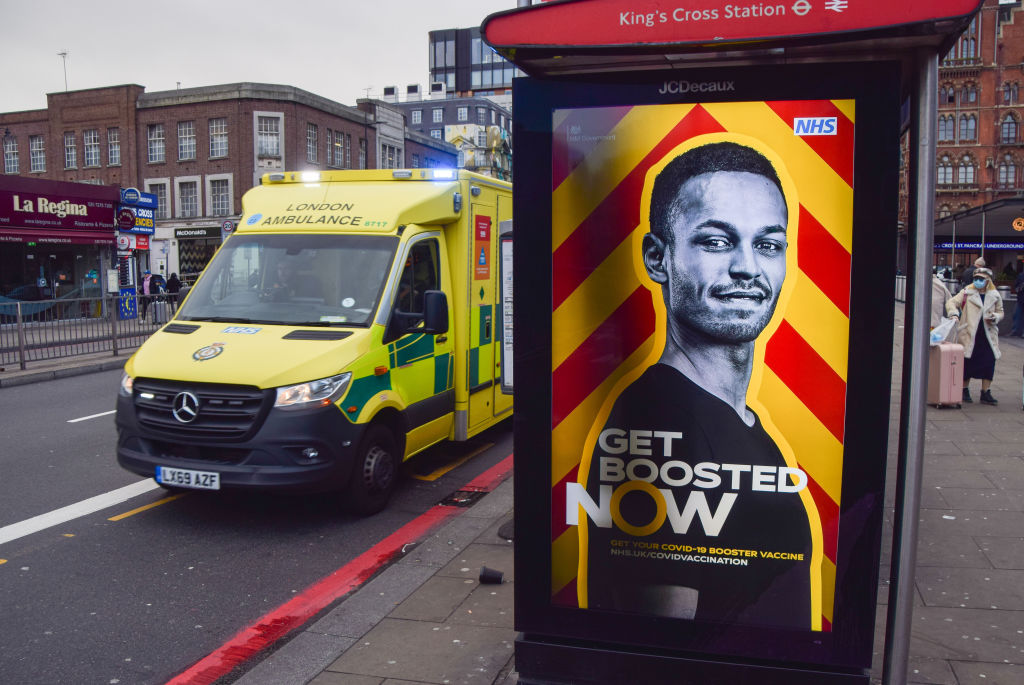 An ambulance passes by a government advert urging people to