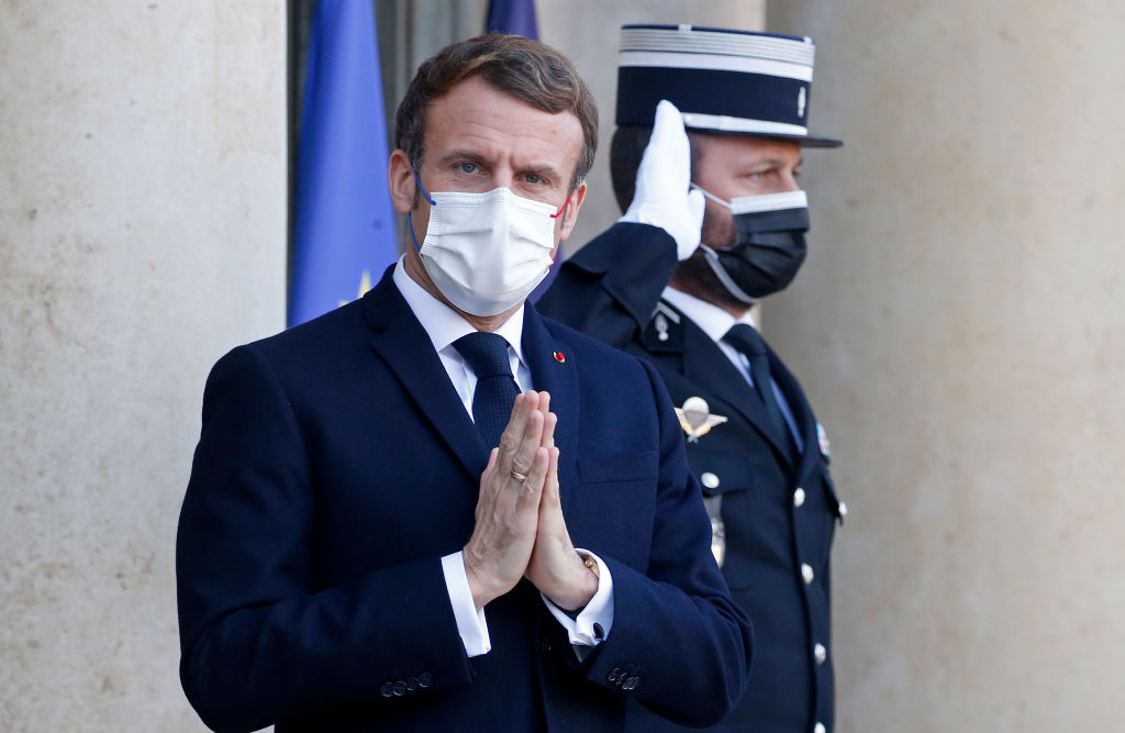 PARIS, FRANCE - JANUARY 11: French President Emmanuel Macron wearing a protective face mask salutes journalists as he waits for the President of the European Council, Charles Michel prior to their working lunch at the Elysee Presidential Palace on January 11, 2022 in Paris, France. The working lunch take place within the framework of the launch of the French Presidency of the Council of the European Union. (Photo by Chesnot/Getty Images)