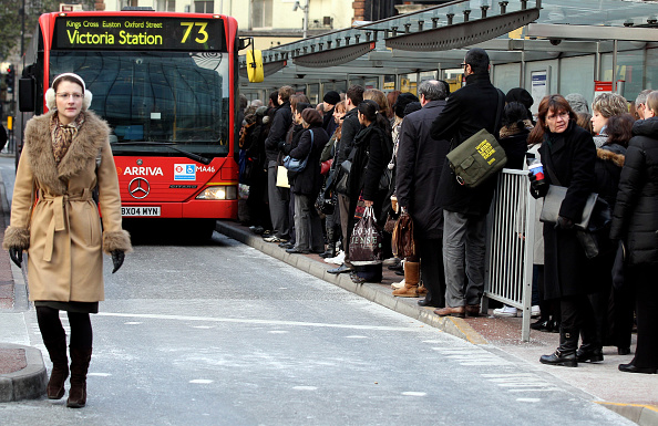 Commuters wait to travel on a bus outside Victoria Station. (Photo by Oli Scarff/Getty Images)