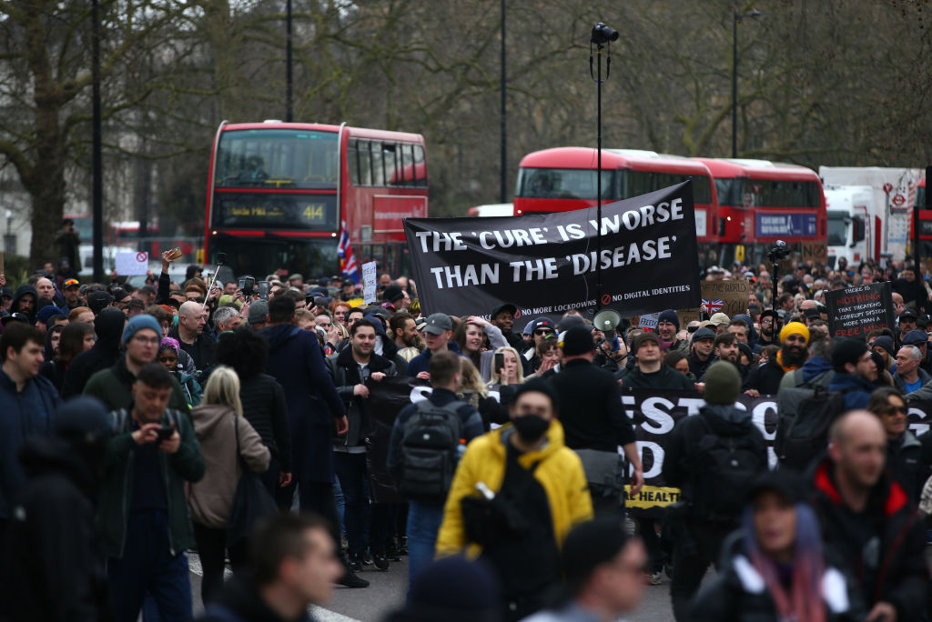 Protesters carry a sign saying "The 'cure' is worse than the 'disease'" as they march during a "World Wide Rally For Freedom" protest in London, England. (Photo by Hollie Adams/Getty Images)
