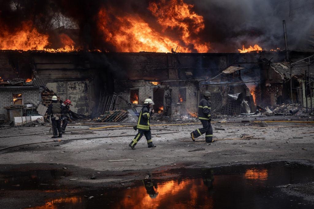 Firefighters work to extinguish a fire at a warehouse after it was  hit by Russian shelling 