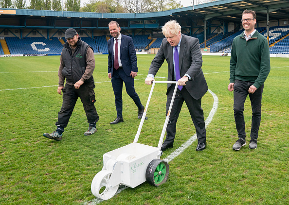 BURY, ENGLAND - APRIL 25: UK Prime Minister Boris Johnson paints over the white line of the centre circle during a visit to Bury FC at their Gigg Lane ground, on April 25, 2002 in Bury, Greater Manchester, England.  (Photo Danny Lawson - WPA Pool/Getty Images)