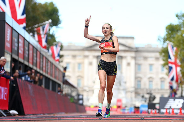 LONDON, ENGLAND - OCTOBER 03: Charlotte Purdue of Great Britain celebrates as she crosses the finish line in the Women's Elite Race during the 2021 Virgin Money London Marathon at Tower Bridge on October 03, 2021 in London, England. (Photo by Alex Davidson/Getty Images)