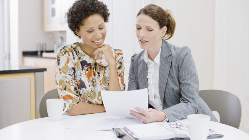 Women discussing investment strategies in a financial office, highlighting the gender confidence gap in UK investing pract...