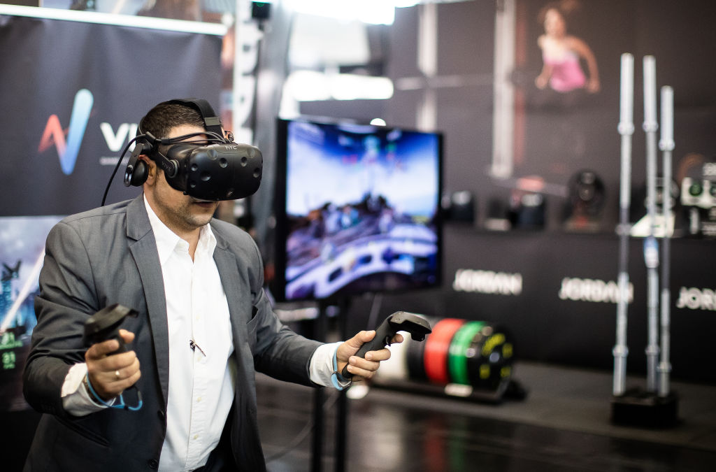COLOGNE, GERMANY - APRIL 07: A visitor tests a VR training equipment during the trade show FIBO - Global Fitness on April 07, 2019 in Cologne, Germany. The FIBO is one of the largest trade shows for fitness, wellness and health.  (Photo by Lars Baron/Getty Images)