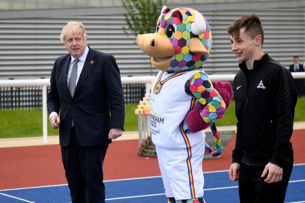 BIRMINGHAM, ENGLAND - MAY 12: UK Prime Minister Boris Johnson (L) lines up with the Commonwealth Games Mascot, Perry The Bull on the training track during a visit to the Alexander Stadium on May 12, 2022 in Birmingham, England. (Photo by Oli Scarff - WPA Pool/Getty Images)