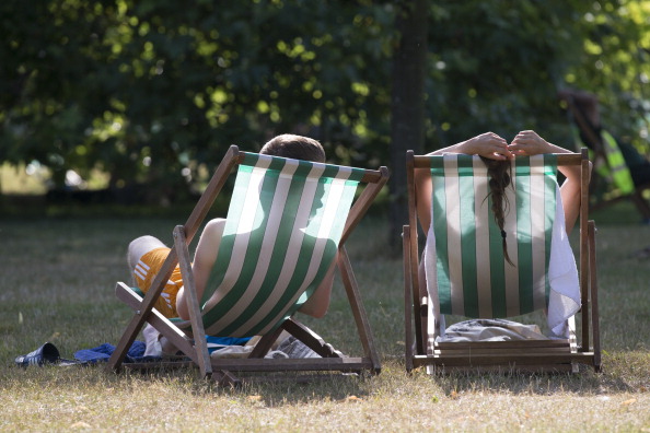 LONDON, ENGLAND - JULY 18:  A couple relax on deckchairs in the warm weather in Hyde Park on July 18, 2014 in London, England. The Met Office has issued a heatwave alert as temperatures soar to their highest of the year.  (Photo by Oli Scarff/Getty Images)