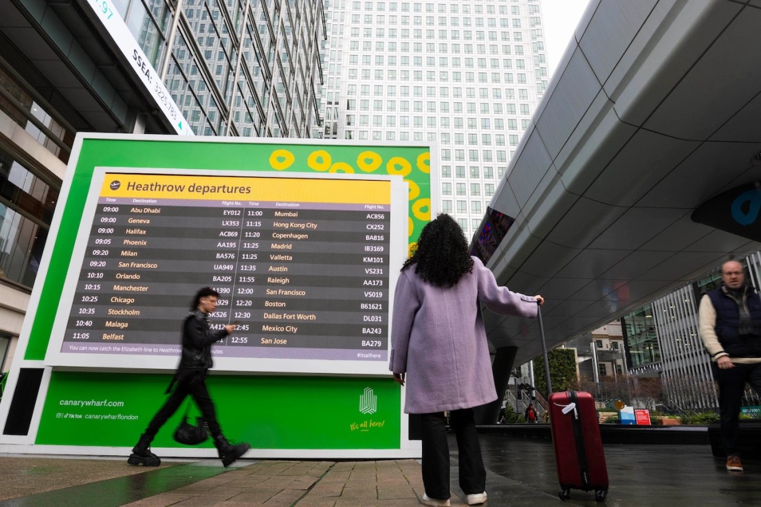 Passengers at Canary Wharf in London where live Heathrow departure boards have been installed to mark the extension of the Elizabeth line, which is now open. (Photo credit: David Parry/PA Wire.)
