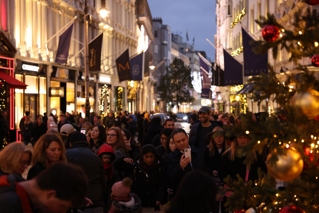Shoppers take pictures with a Christmas tree at New Bond Street. (Photo by Hollie Adams/Getty Images)