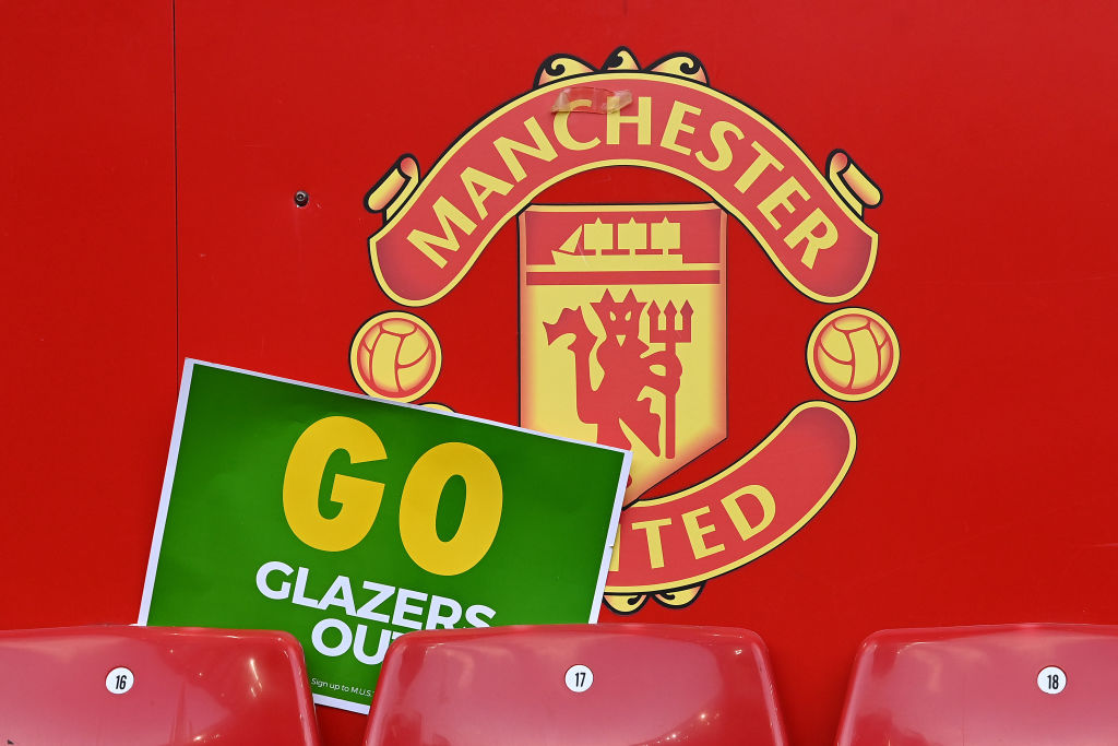 Manchester United logo with a sign telling the Glazers to "go"