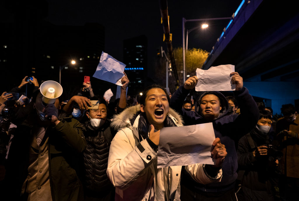 BEIJING, CHINA - NOVEMBER 28: A protester shouts slogans against China's strict zero COVID measures on November 28, 2022 in Beijing, China. Protesters took to the streets in multiple Chinese cities after a deadly apartment fire in Xinjiang province sparked a national outcry as many blamed COVID restrictions for the deaths. (Photo by Kevin Frayer/Getty Images)