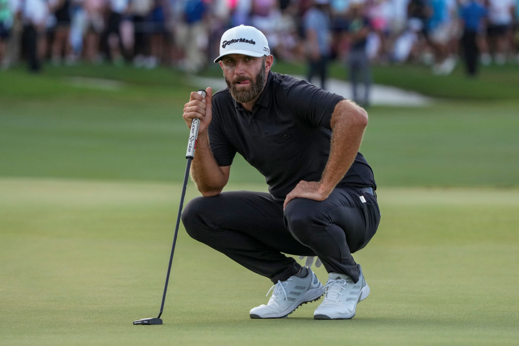 Dustin Johnson crouching on the LIV course in Miami