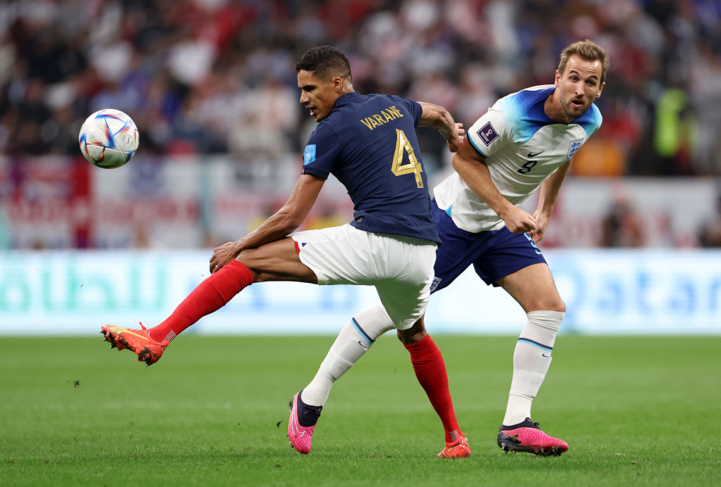 AL KHOR, QATAR - DECEMBER 10: Harry Kane of England battles for possession with Raphael Varane of France during the FIFA World Cup Qatar 2022 quarter final match between England and France at Al Bayt Stadium on December 10, 2022 in Al Khor, Qatar. (Photo by Catherine Ivill/Getty Images)