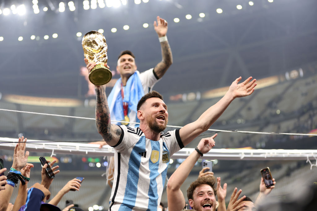 LUSAIL CITY, QATAR - DECEMBER 18: Lionel Messi of Argentina celebrates with teammates and the FIFA World Cup Qatar 2022 Winner's Trophy after the team's victory during the FIFA World Cup Qatar 2022 Final match between Argentina and France at Lusail Stadium on December 18, 2022 in Lusail City, Qatar. (Photo by Clive Brunskill/Getty Images)