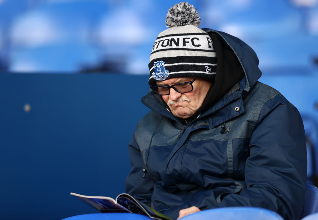 Everton fan reads the match programme