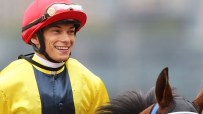 Alexis Badel poised at Happy Valley Racecourse, focused on upcoming races, highlighting his successful jockey career in Ho...