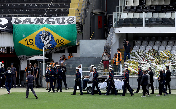 Pele's coffin lay in state at the stadium of his former club Santos before being carried through the city on Tuesday