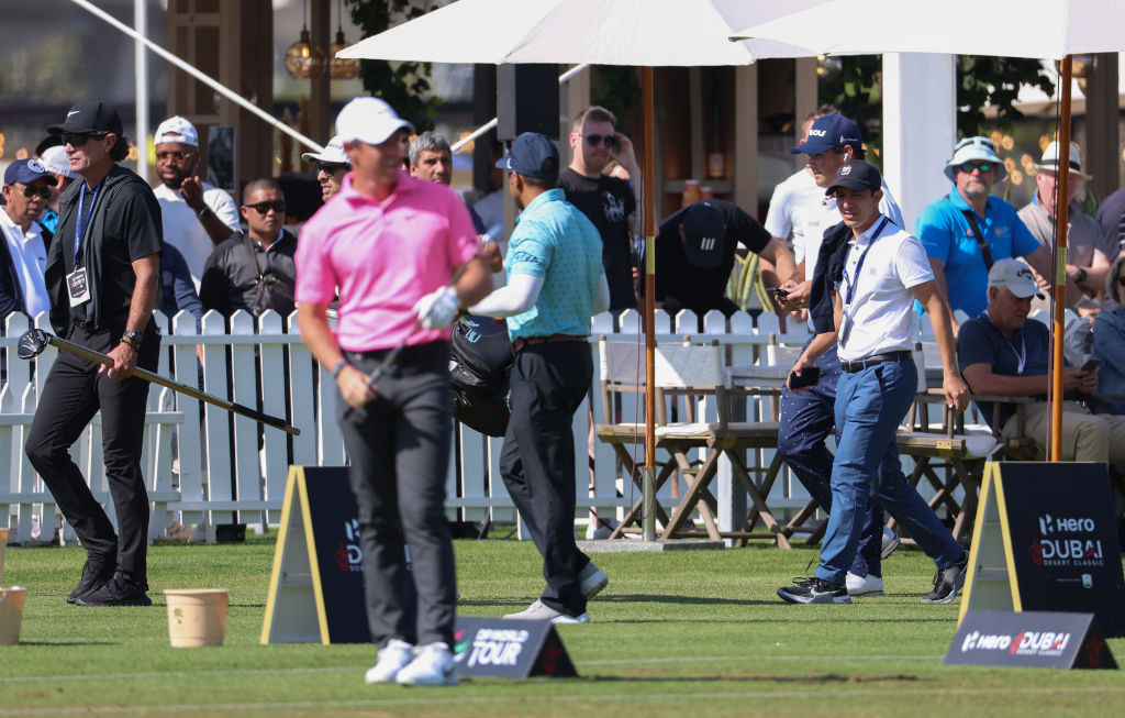 McIlroy (in pink) and Reed (to rear in navy cap) clashed on the driving range last week in Dubai