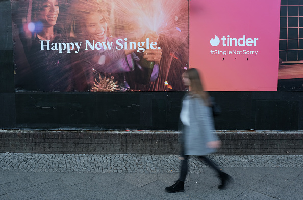 An activist investor is trying to turn around Match Group as the Tinder and Hinge owner faces a stock slump. BERLIN, GERMANY - FEBRUARY 18: A young woman walks past a billboard advertisement for the dating app Tinder on February 18, 2019 in Berlin, Germany. Tinder has emerged as one of the most popular dating apps.  (Photo by Sean Gallup/Getty Images)