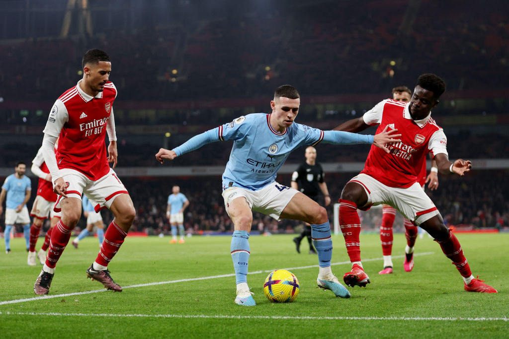 LONDON, ENGLAND - FEBRUARY 15: Phil Foden of Manchester City is challenged by Bukayo Saka of Arsenal during the Premier League match between Arsenal FC and Manchester City at Emirates Stadium on February 15, 2023 in London, England. (Photo by Julian Finney/Getty Images)
