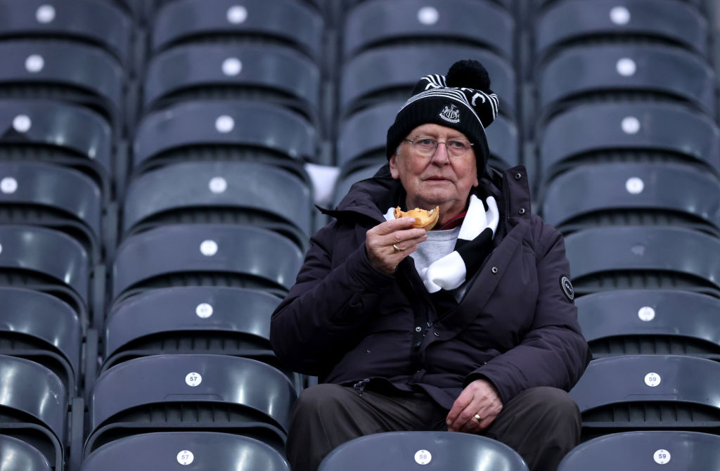 NEWCASTLE UPON TYNE, ENGLAND - FEBRUARY 18: A Newcastle United fan eats from his seat prior to the Premier League match between Newcastle United and Liverpool FC at St. James Park on February 18, 2023 in Newcastle upon Tyne, England. (Photo by George Wood/Getty Images)