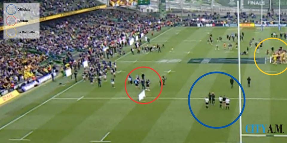 Sexton (in red) watching La Rochelle (yellow) celebrate their Champions Cup win while the officials (blue) also watch on.