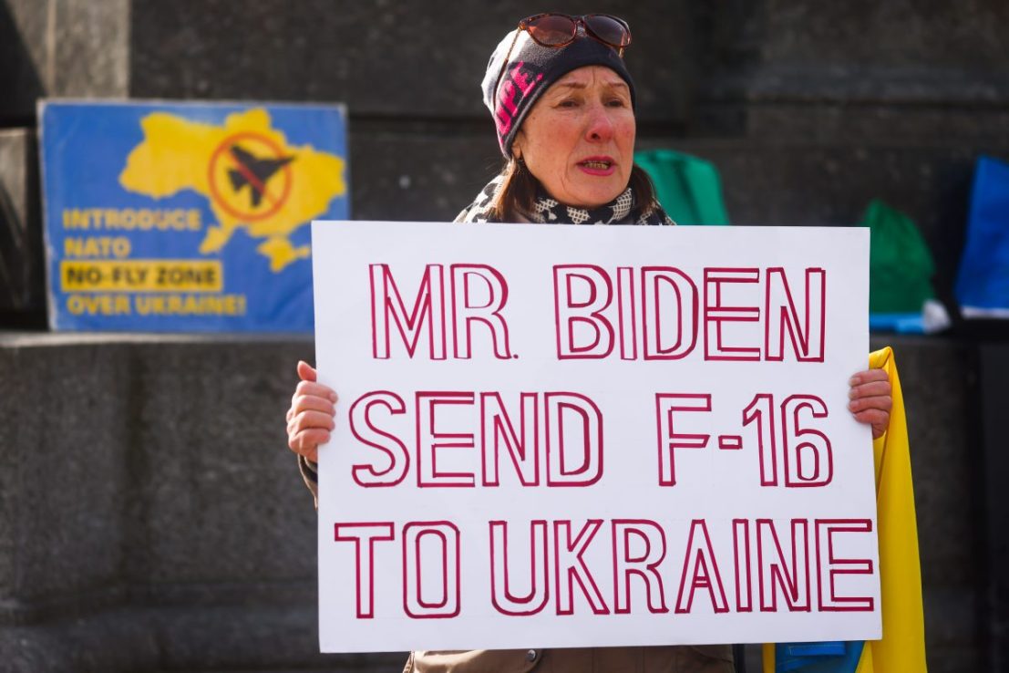 A woman holds a banner 'Mr Biden Send F-16 To Ukraine' during a daily demonstration of solidarity with Ukraine at the Main Square one day ahead of one-year anniversary of Russian invasion on Ukraine. (Photo by Beata Zawrzel/NurPhoto via Getty Images)