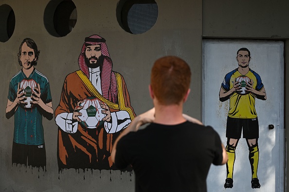 Collages from street artist Alexsandro Palombo show new coach of Saudi Arabia, Italian Roberto Mancini (L), Saudi Prince Mohammed bin Salman and Al Nassr Portuguese star Cristiano Ronaldo (R) holding a blooded ball in their hands as part of a serie called «Welcome to Saudi Arabia» on September 19, 2023 on the walls of San Siro stadium ticketing desk in Milan. (Photo by GABRIEL BOUYS / AFP) / RESTRICTED TO EDITORIAL USE - MANDATORY MENTION OF THE ARTIST UPON PUBLICATION - TO ILLUSTRATE THE EVENT AS SPECIFIED IN THE CAPTION (Photo by GABRIEL BOUYS/AFP via Getty Images)