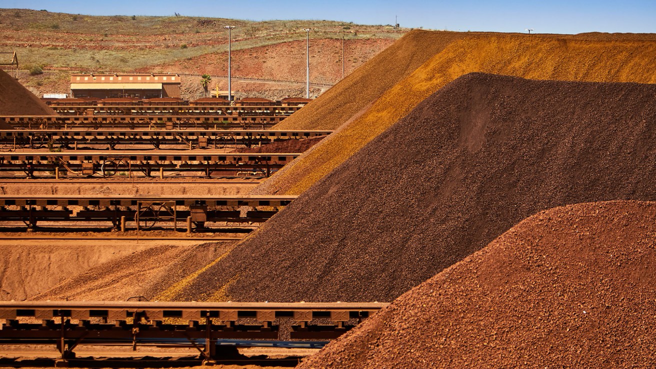 Rio Tinto has posted a steady trading update after a turbulent window of trading.(Source: Rio Tinto, Pilbara Operations, piles of iron ore at Cape Lambert, Australia)
