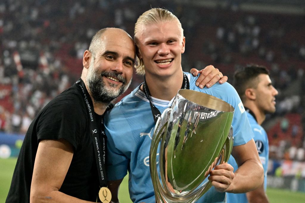 Manchester City's Norwegian striker #09 Erling Haaland and Manchester City's Spanish manager Pep Guardiola (L) celebrate with the trophy after winning the 2023 UEFA Super Cup football match between Manchester City and Sevilla at the Georgios Karaiskakis Stadium in Piraeus on August 16, 2023. (Photo by Louisa Gouliamaki / AFP) (Photo by LOUISA GOULIAMAKI/AFP via Getty Images)