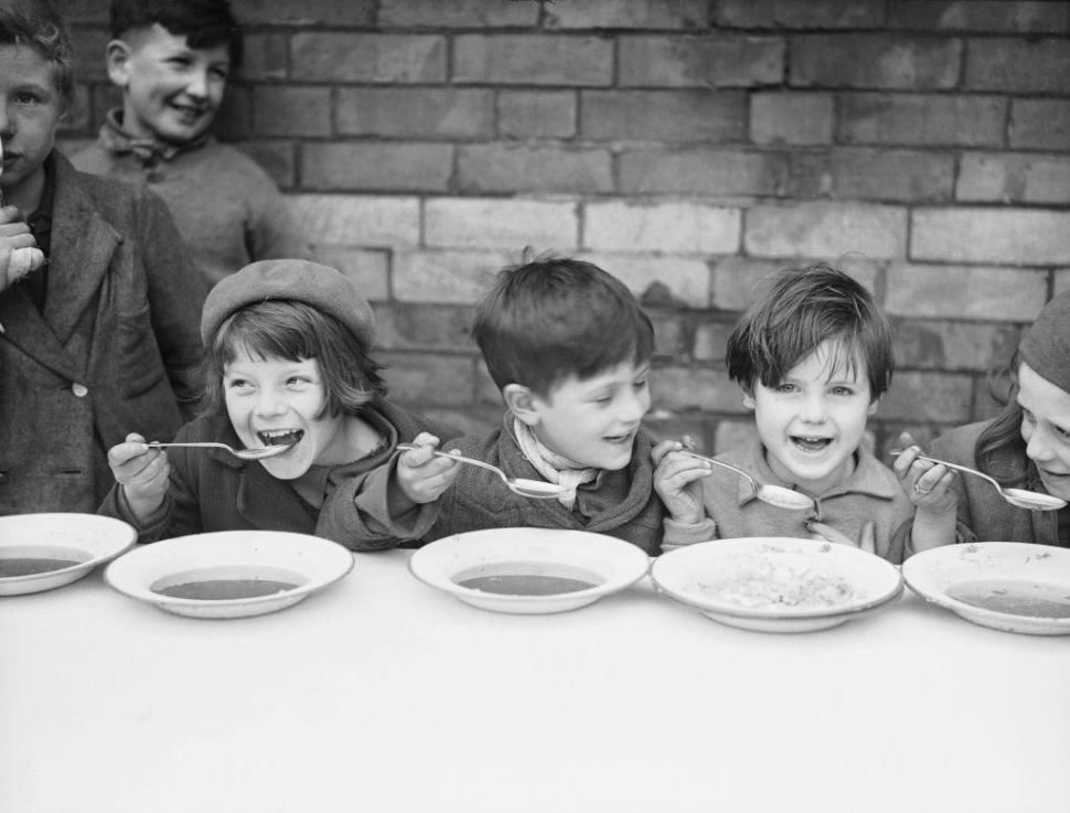 9th March 1937:  A group of children having a free midday meal at a school in Newport