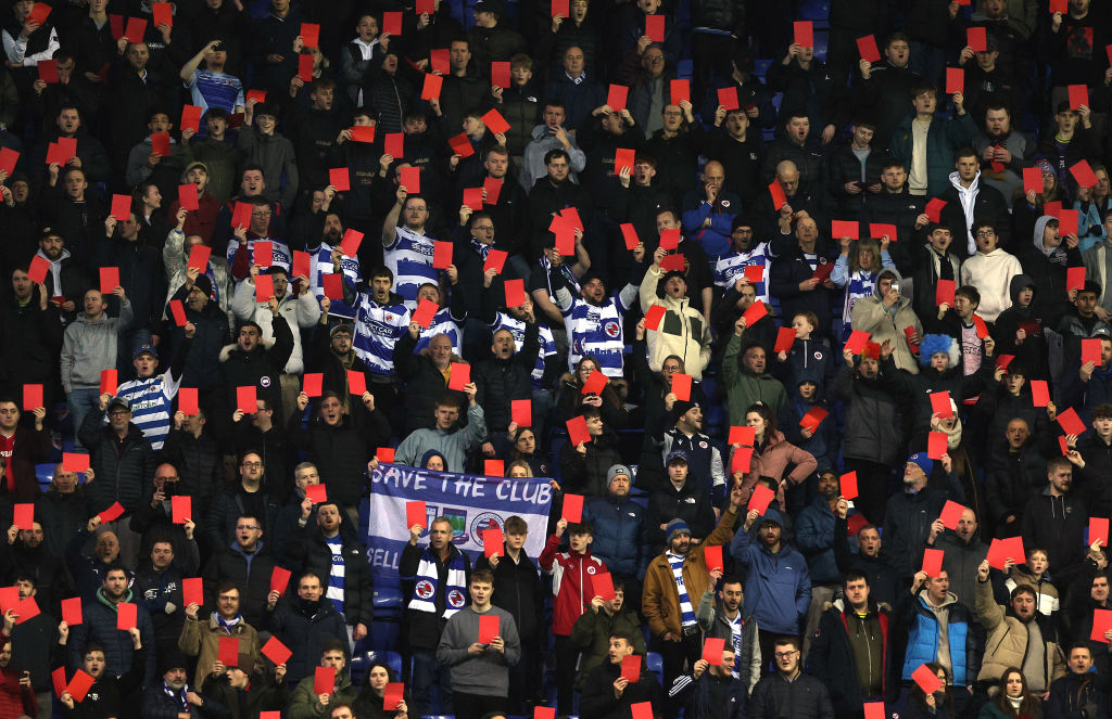 READING, ENGLAND - FEBRUARY 20:  Reading fans show red cards in protest during the Sky Bet League One match between Reading and Port Vale at Select Car Leasing Stadium on February 20, 2024 in Reading, England. (Photo by Warren Little/Getty Images)