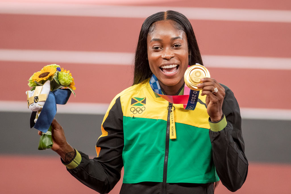 TOKYO, JAPAN August 4:  Elaine Thompson-Herah of Jamaica on the podium with her gold medal for her victory in the 200m for women during the Track and Field competition at the Olympic Stadium at the Tokyo 2020 Summer Olympic Games on August 4th, 2021 in Tokyo, Japan. (Photo by Tim Clayton/Corbis via Getty Images)