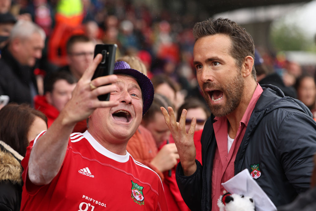 WREXHAM, WALES - AUGUST 5: Ryan Reynolds the co-owner of Wrexham greets the fans prior to Wrexham's first game back in the football league prior to the Sky Bet League Two match between Wrexham and Milton Keynes Dons at Racecourse Ground on August 5, 2023 in Wrexham, Wales. (Photo by Matthew Ashton - AMA/Getty Images)