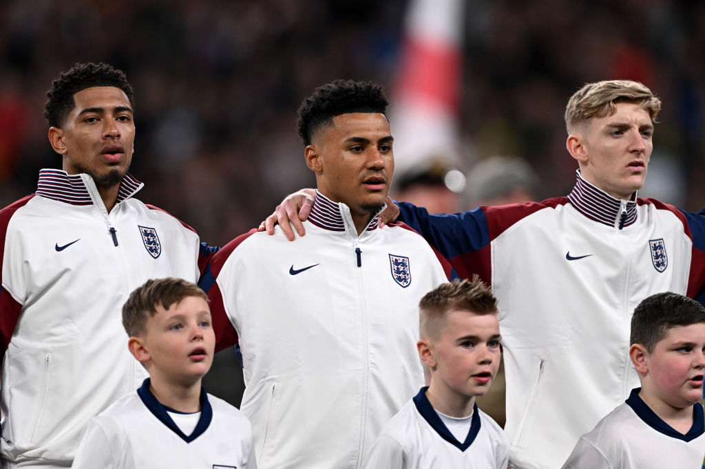 LONDON, ENGLAND - MARCH 23: Jude Bellingham, Ollie Watkins and Anthony Gordon of England sing the national anthem prior to the international friendly match between England and Brazil at Wembley Stadium on March 23, 2024 in London, England. (Photo by Mike Hewitt/Getty Images)