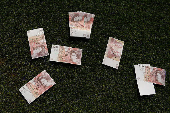 NOTTINGHAM, ENGLAND - AUGUST 14: Fake money is seen on the pitch after being thrown by West Ham United fans during the Premier League match between Nottingham Forest and West Ham United at City Ground on August 14, 2022 in Nottingham, England. (Photo by Michael Regan/Getty Images)