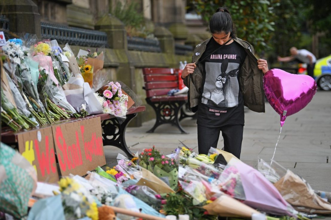 MANCHESTER, ENGLAND - MAY 24:  Thirteen year old Iqra Saied, who attended the Ariana Grande concert 
looks at floral tributes and messages as the working day begins on May 24, 2017 in Manchester, England. An explosion occurred at Manchester Arena on the evening of May 22 as concert goers were leaving the venue after Ariana Grande had performed. Greater Manchester Police are treating the explosion as a terrorist attack and have confirmed 22 fatalities and 59 injured.  (Photo by Jeff J Mitchell/Getty Images)
