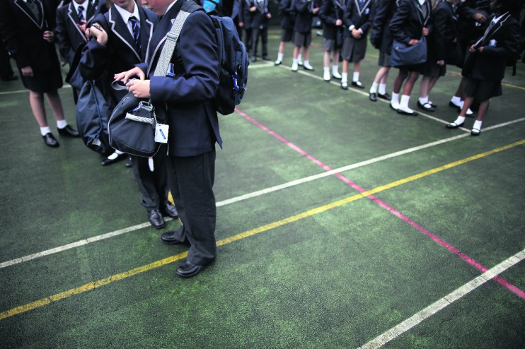 Pupils wait for school buses at a West London school (Photo by Matthew Lloyd/Getty Images)