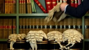 British barristers wigs symbolizing legal tradition amidst rising class action lawsuits affecting UK economy