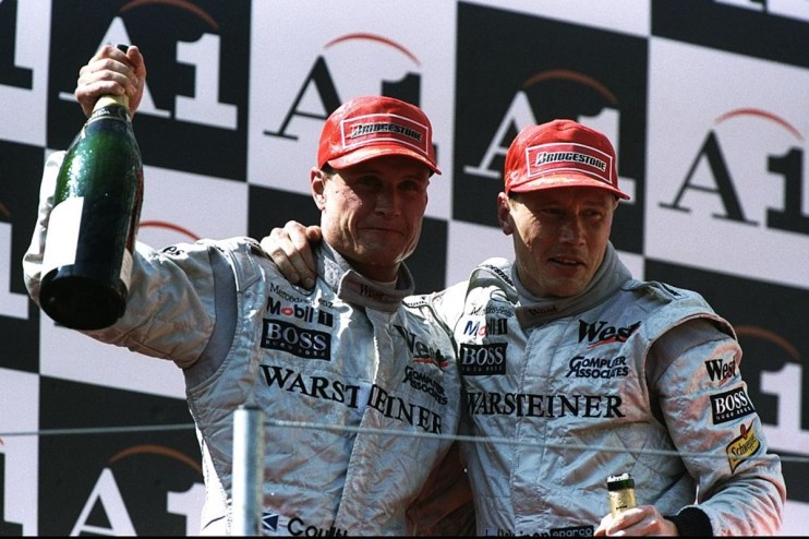 McLaren-Mercedes drivers David Coulthard (left) of Great Britain and Mika Hakkinen of Finland celebrate with champagne after the Austrian Grand Prix at the A1 Ring in Spielberg, Austria. Hakkinen finished in first place and Coulthard in second. Credit: Mike Cooper/Allsport