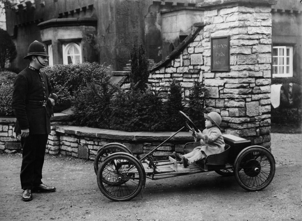 10th February 1930:  A policeman wonders whether to book Basil Sanderson, England's youngest motorist as he drives his vehicle out of the Selsdon Park Hotel.  (Photo by Fox Photos/Getty Images)