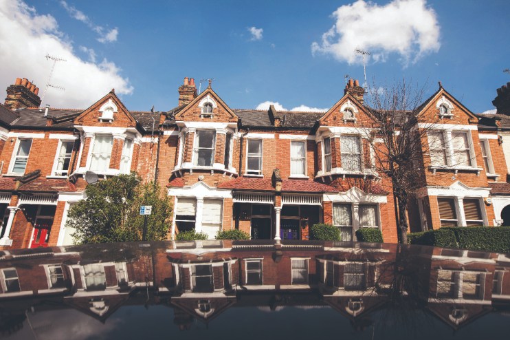 The roof of a parked automobile reflects a row of residential properties in the Battersea area of London, Photographer: Jason Alden/Bloomberg via Getty Images