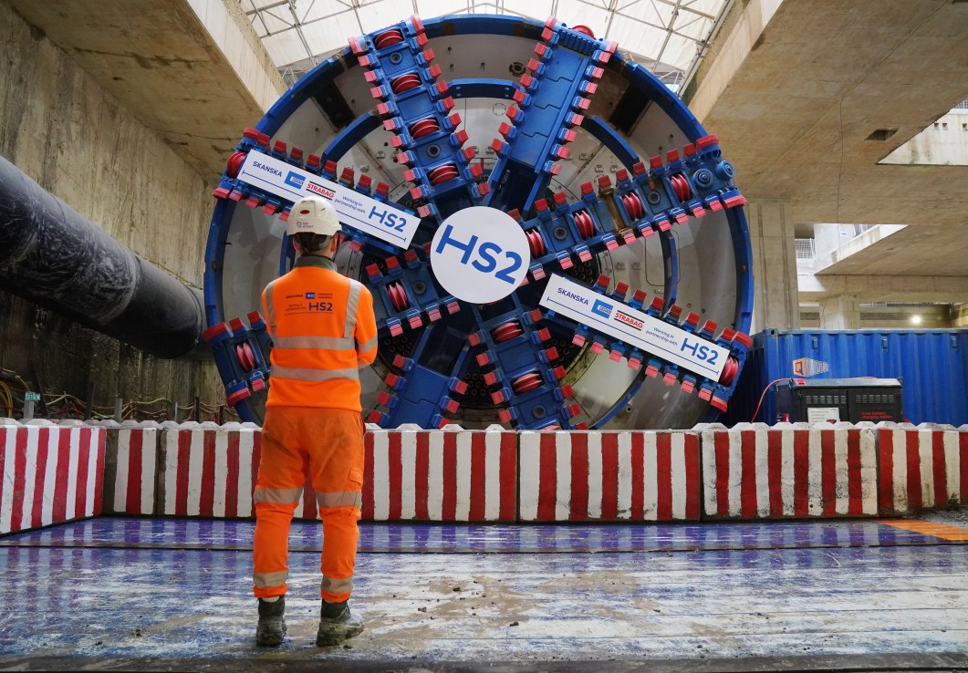 An HS2 worker standing in front of tunnel boring machine Karen at the Old Oak Common station box site during preparations for completing the 4.5 mile HS2 tunnelling to London Euston. HS2 is in a "very serious situation" and needs a "fundamental reset", the new boss of the company building the high-speed railway has warned. Mark Wild, chief executive of HS2 Ltd, said he is committed to ensuring the railway opens "safely and efficiently". Issue date: Monday December 30, 2024. PA Photo. See PA story RAIL HS2. Photo credit should read: Jonathan Brady/PA Wire