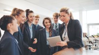 A female teacher talking to a group of students in a science room