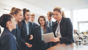 A female teacher talking to a group of students in a science room