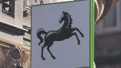 Lloyds Bank exterior with falling stock prices as shares drop on FTSE 100 amid banking sector fears